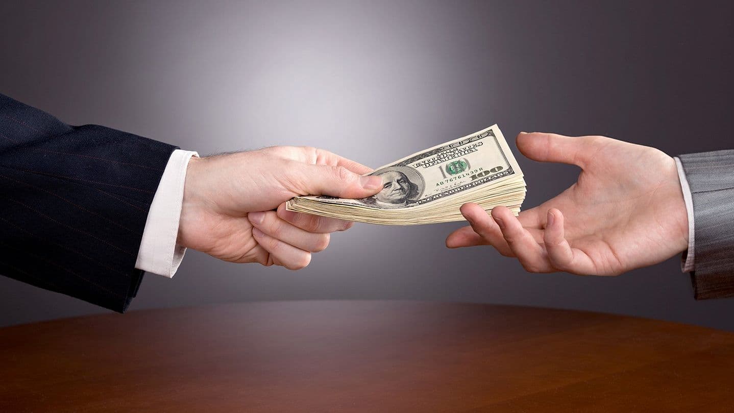 Lending money handing over paying cash (Shutterstock)