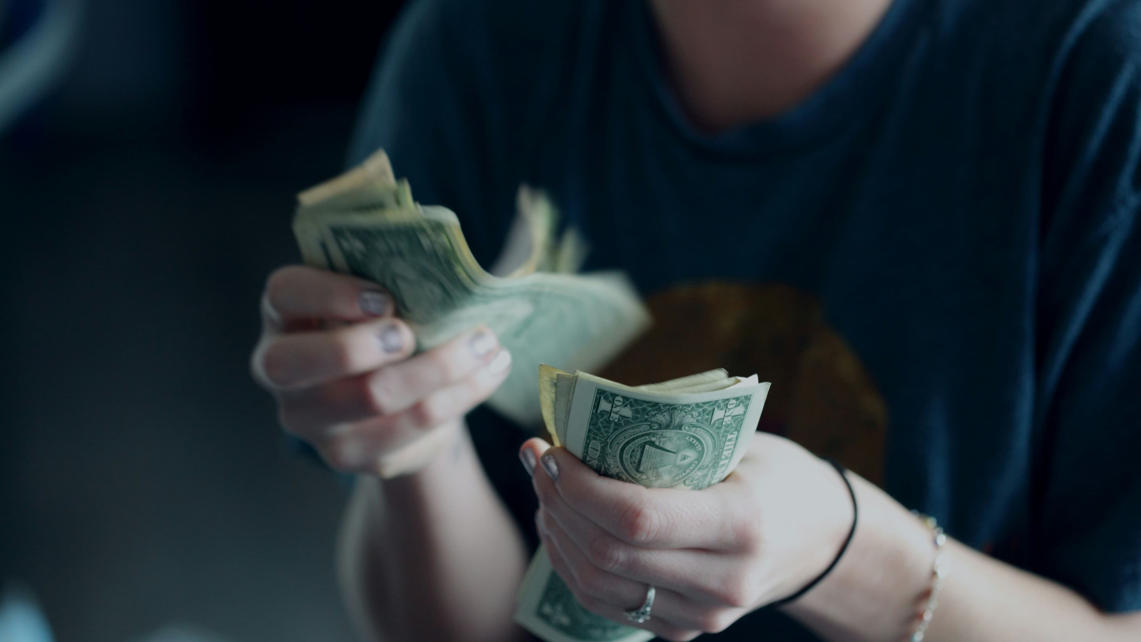 16:9 crop counting dollar bills (Alexander Grey/Unsplash)