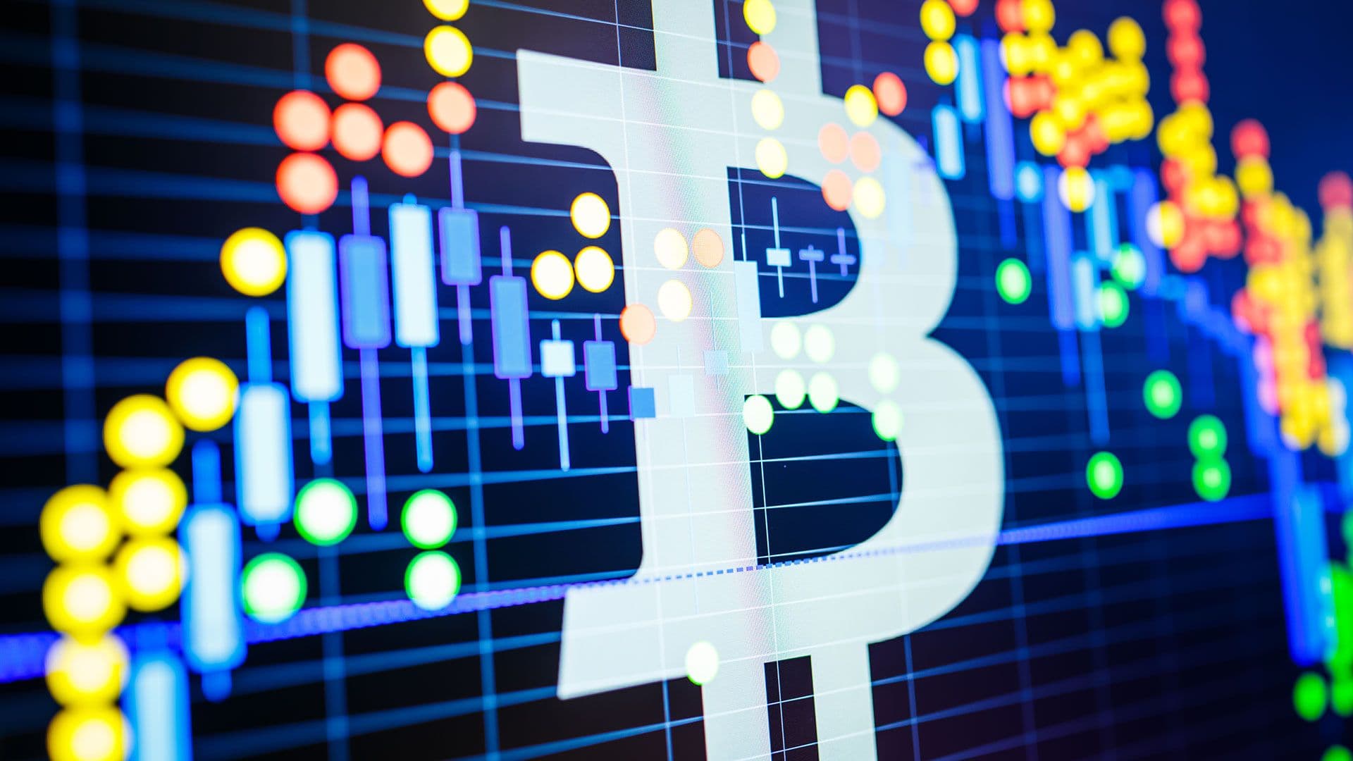 Data analyzing in exchange stock market: the candle chars on display. Analytics price change cryptocurrency BTC to USD (Bitcoin / US Dollar), the most popular pair in the world. Big Bitcoin logo.